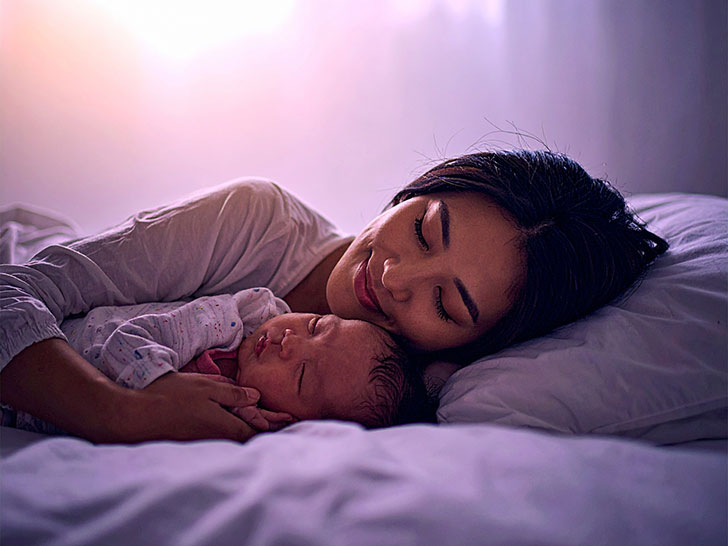 赤ちゃんと一緒に眠るお母さん