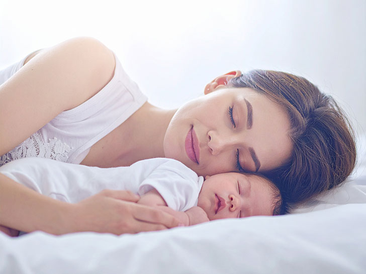 赤ちゃんと一緒に眠るお母さん