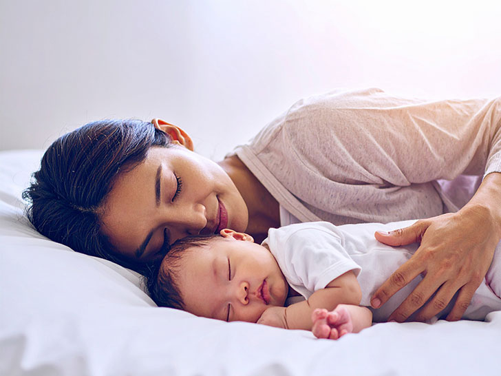 赤ちゃんと一緒に眠るお母さん