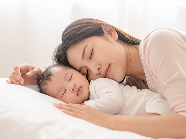 赤ちゃんと一緒に眠るお母さん