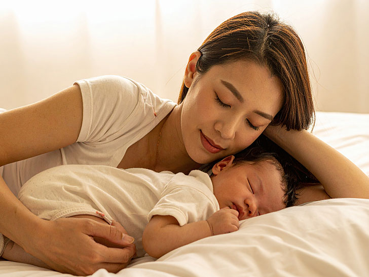 赤ちゃんと一緒に眠るお母さん