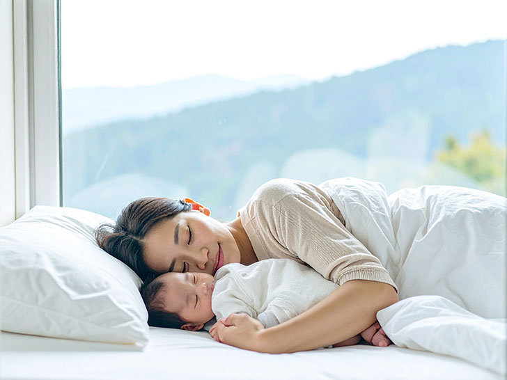 赤ちゃんと一緒に眠るお母さん
