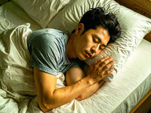 ベッドで眠る若い男性