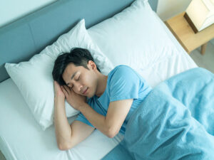 ベッドで眠る若い男性