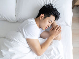ベッドで眠る若い男性