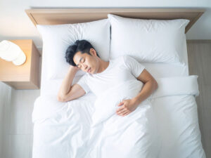 ベッドで眠る若い男性