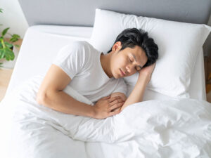 ベッドで眠る若い男性