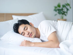 ベッドで眠る若い男性