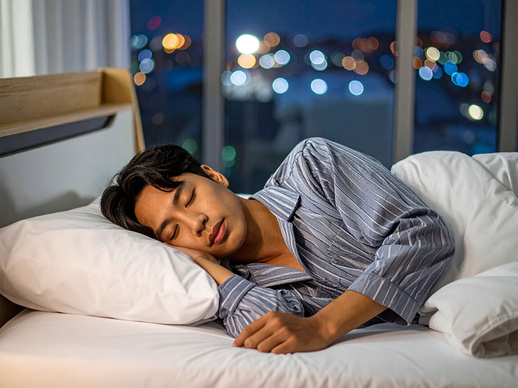 ベッドで眠る若い男性