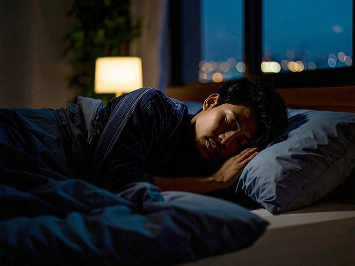 ベッドで眠る若い男性