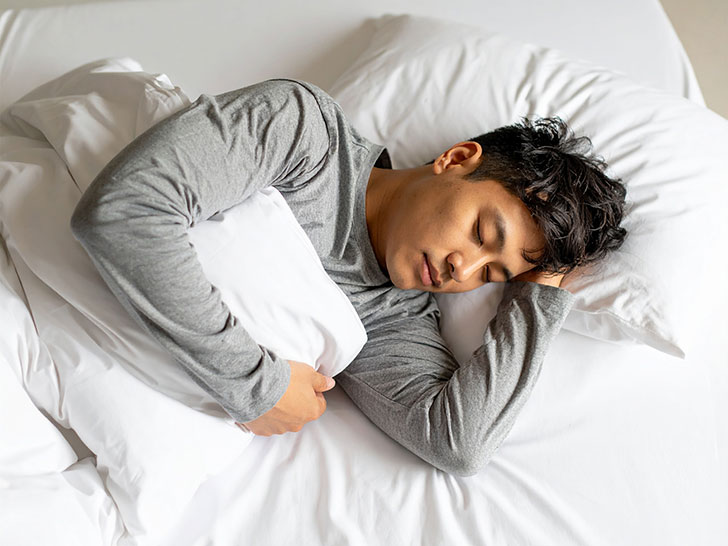 ベッドで眠る若い男性