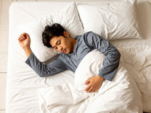 ベッドで眠る若い男性