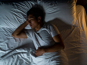 ベッドで眠る若い男性