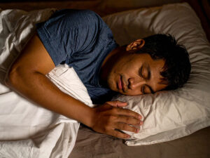 ベッドで眠る若い男性