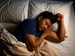 ベッドで眠る若い男性