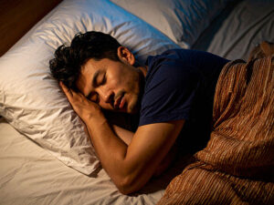 ベッドで眠る若い男性