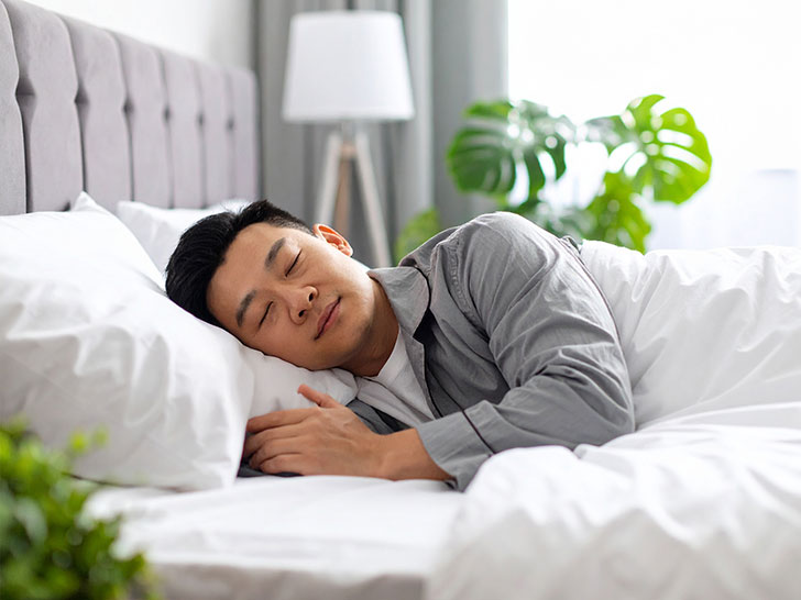 ベッドで眠る若い男性