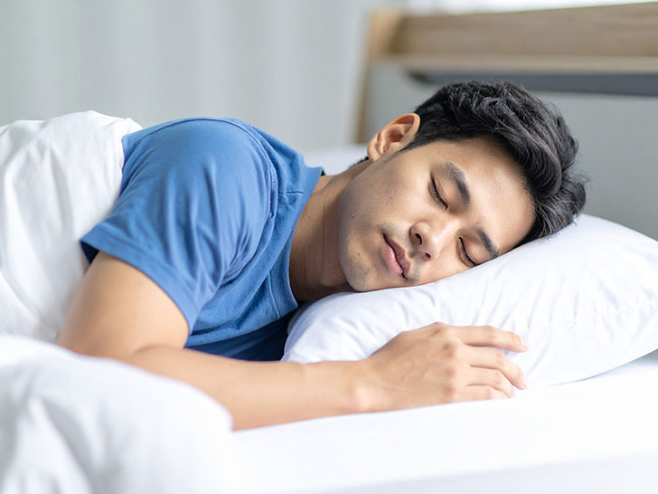 ベッドで眠る若い男性