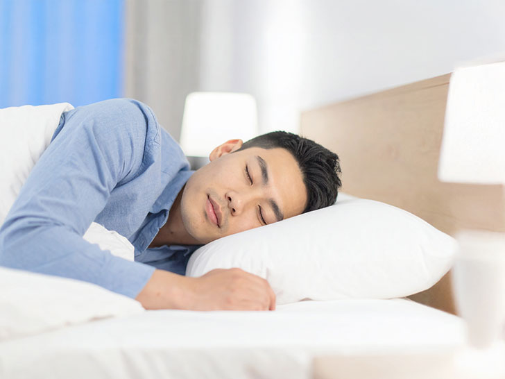ベッドで眠る若い男性