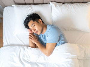ベッドで眠る若い男性
