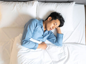ベッドで眠る若い男性