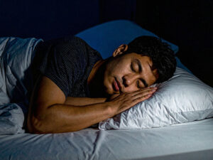 ベッドで眠る若い男性