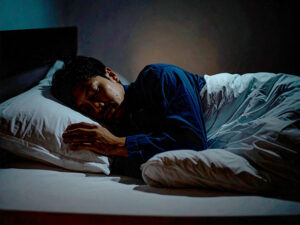 ベッドで眠る若い男性