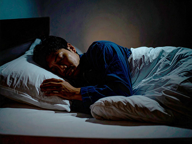 ベッドで眠る若い男性