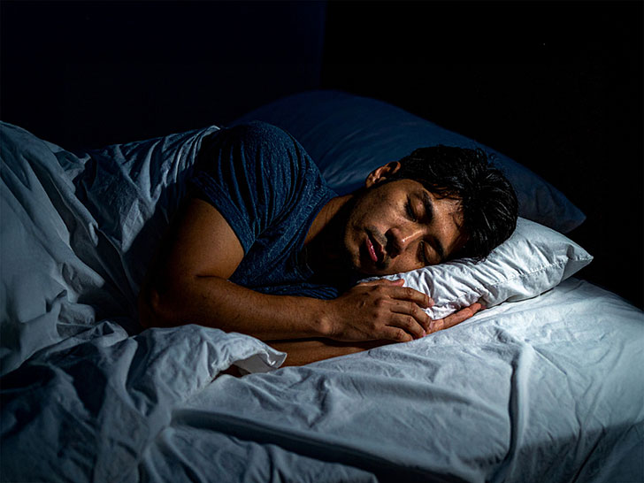 ベッドで眠る若い男性