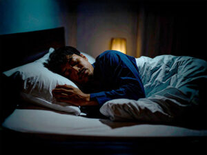 ベッドで眠る若い男性