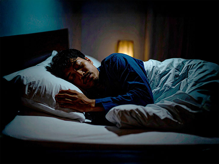 ベッドで眠る若い男性