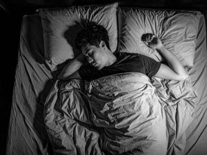 ベッドで眠る若い男性