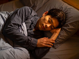 ベッドで眠る若い男性