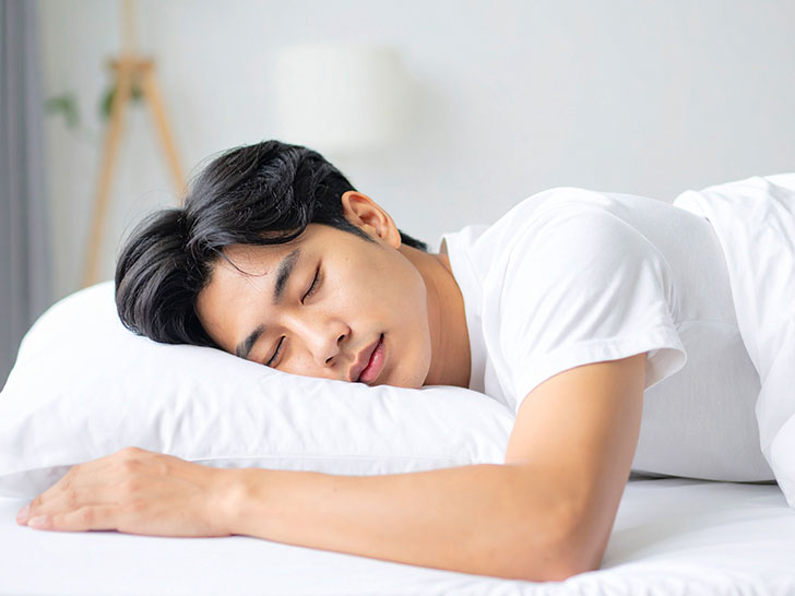 ベッドで眠る若い男性