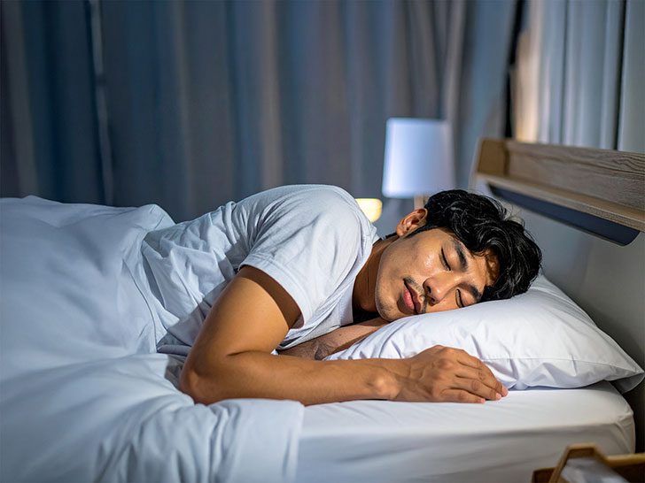 ベッドで眠る若い男性