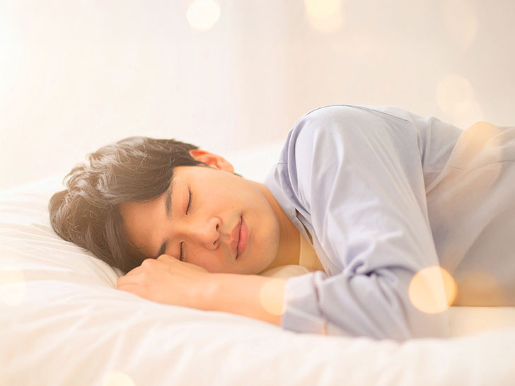 ベッドで眠る若い男性