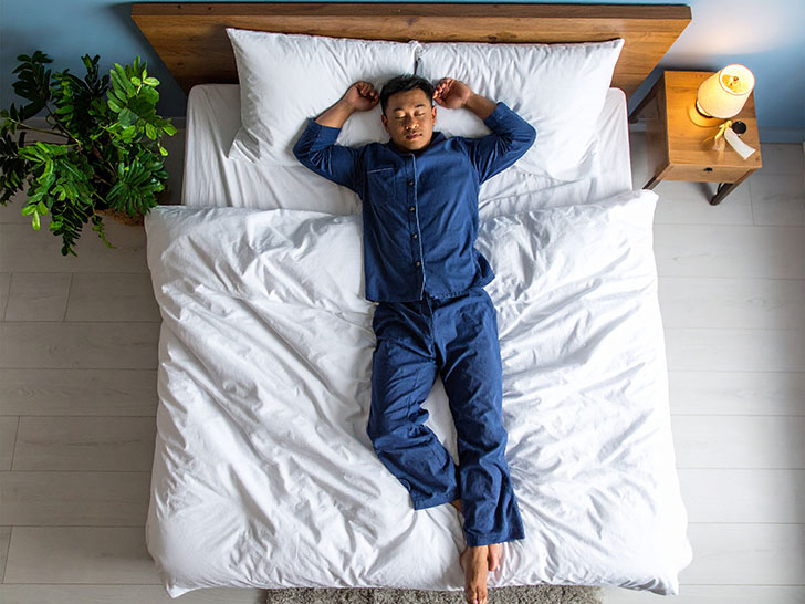 ベッドで眠る若い男性