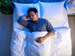 ベッドで眠る若い男性