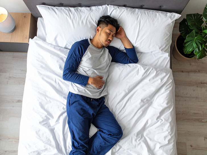 ベッドで眠る若い男性