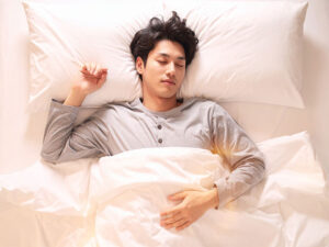 ベッドで眠る若い男性