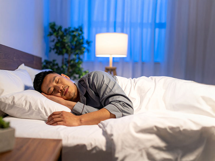 ベッドで眠る若い男性