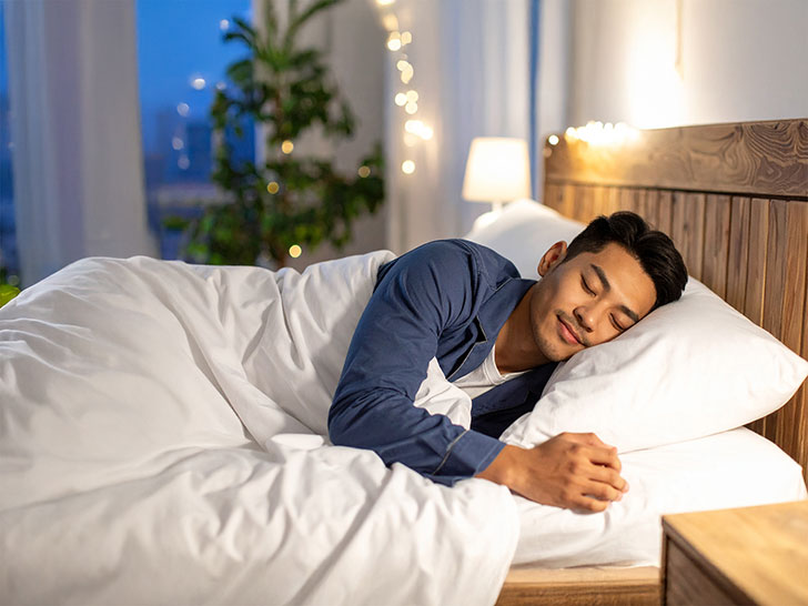 ベッドで眠る若い男性