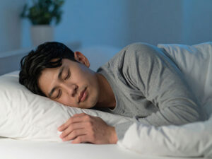 ベッドで眠る若い男性