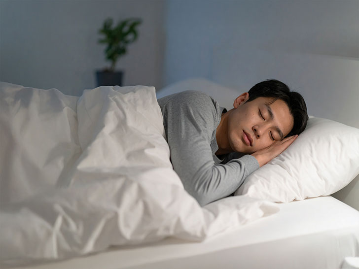 ベッドで眠る若い男性