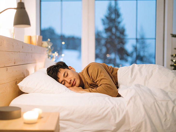 ベッドで眠る若い男性