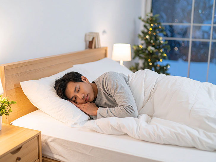 ベッドで眠る若い男性