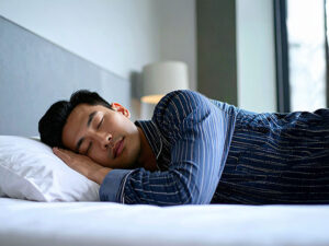 ベッドで眠る若い男性