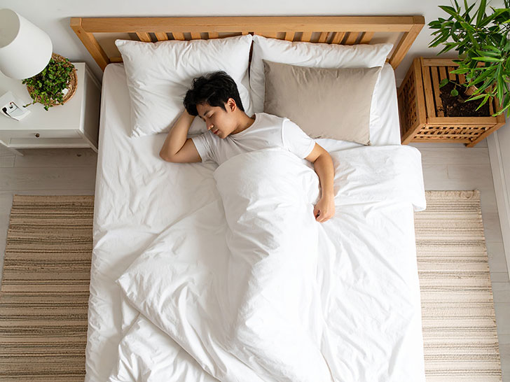 ベッドで眠る若い男性