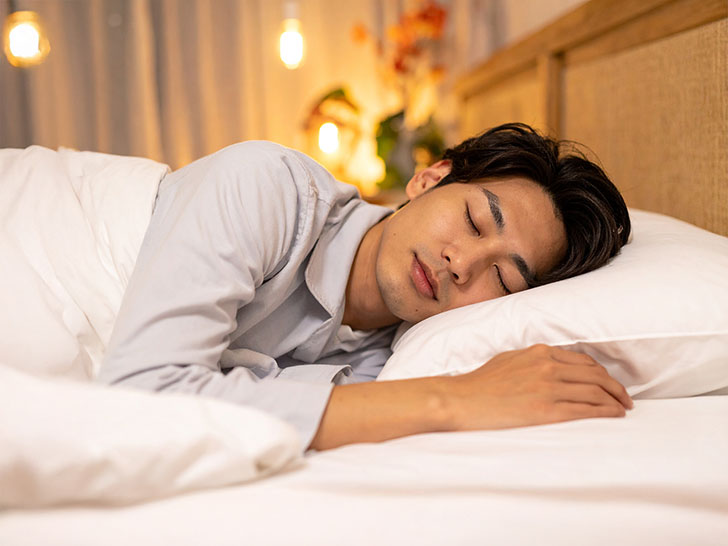 ベッドで眠る若い男性