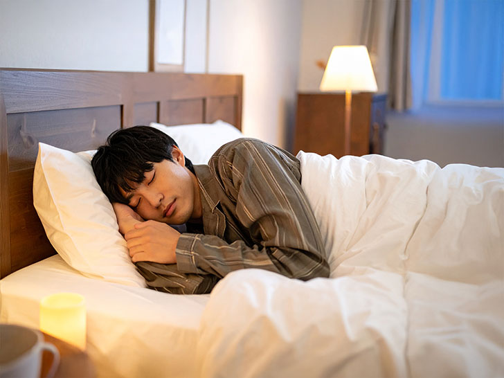ベッドで眠る若い男性
